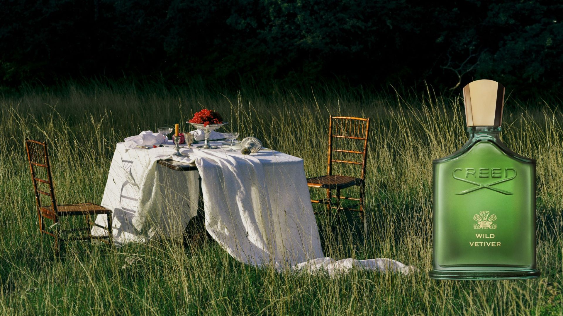 CREED Wild Vetiver 岩蘭野境香水置於草地戶外餐桌場景，營造英倫花園氛圍
